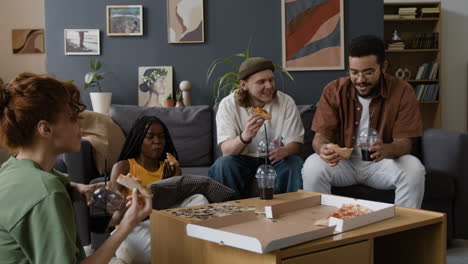 friends eating pizza and drinking at a casual home gathering