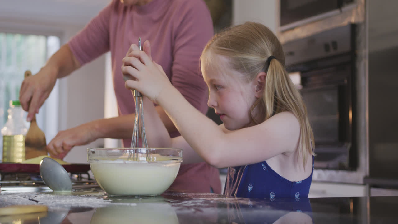 Side view of Caucasian girl cooking with her mother at home