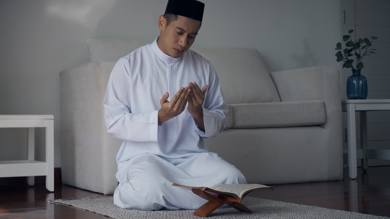 Asian Muslim man reciting surah al-Fatiha passage of the Qur'an, in a daily prayer at home in a single act of sujud called a sajdah or prostration