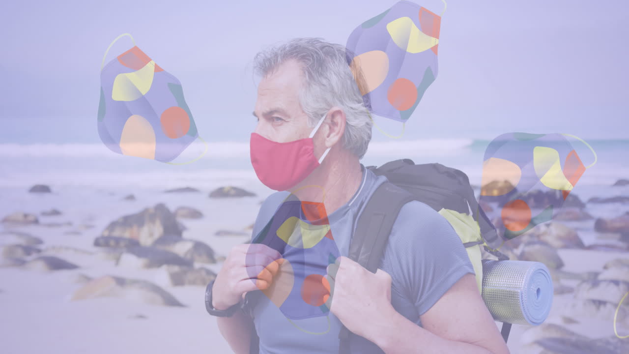 여러 개의 얼굴 마스크가 해변에서 배 ⁇ 을 가진 백인 고령자의 초상화에 대해 움직이고 있습니다.