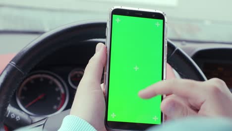 un hombre en un coche con una pantalla verde de teléfono