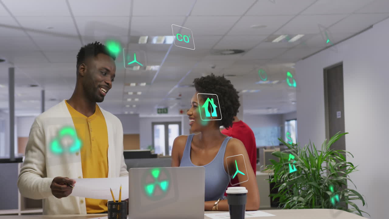 Animation of ecology icons over diverse business people talking in office