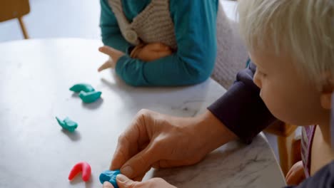 Vater-Und-Kinder-Spielen-Zusammen-Mit-Ton-In-Einem-Komfortablen-Zuhause-4k