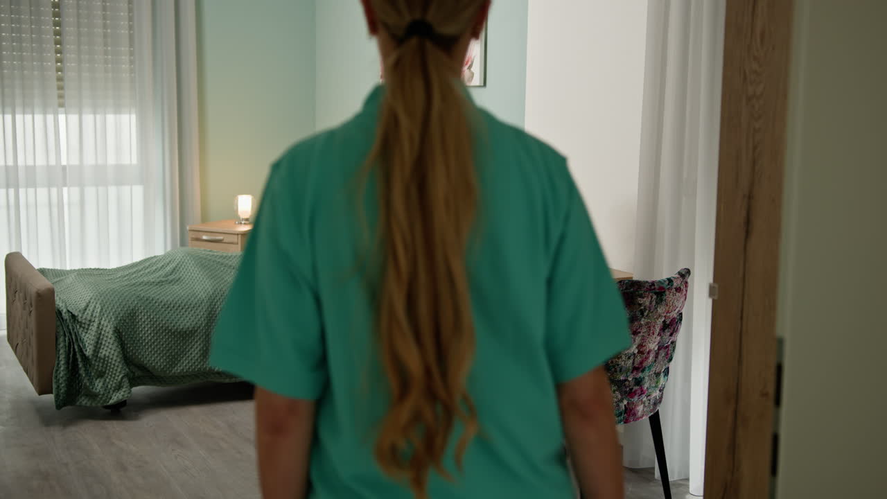 Caregiver assisting elderly patient in a nursing home room