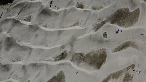 overhead drone shot of stunning sand dunes and people soaking up the sun at nye beach in newport, oregon