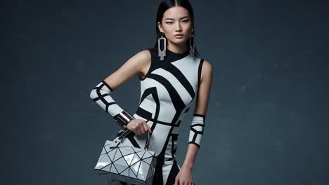 a captivating fashion forward model poses in a striking black and white ensemble, showcasing bold lines and modern accessories in a studio setting