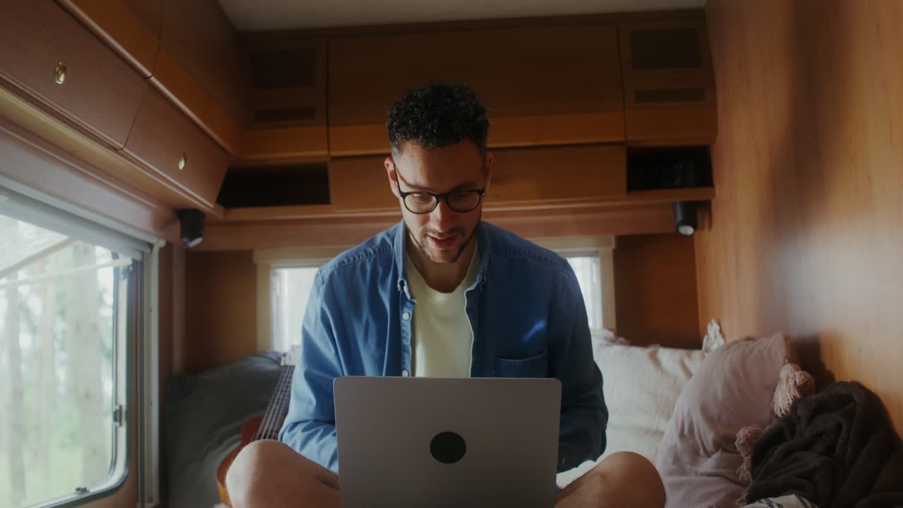 Man working on laptop in an RV