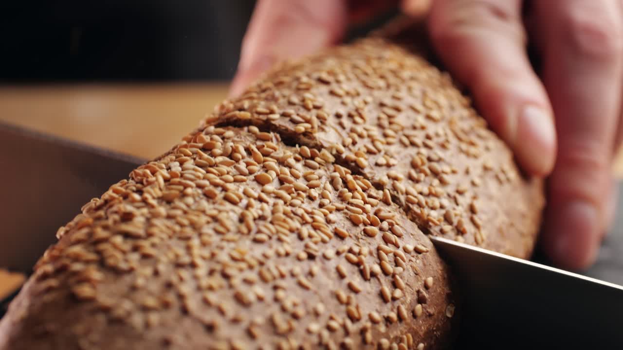 cortando un pan de semillas de sésamo