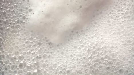 close up overhead view of boiling , bubbly and foamy water