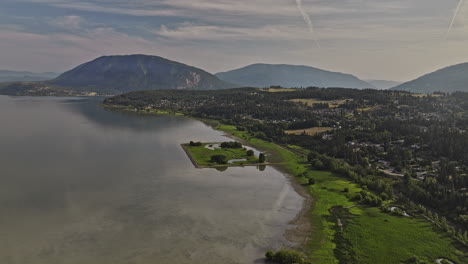 Salmon-Arm-BC-Kanada-Luftaufnahme-Einer-V2-Drohne,-Die-Entlang-Der-Küste-Des-Shuswap-Lake-Fliegt-Und-Malerische-Wohngebiete-Am-Seeufer-Und-Eine-Atemberaubende-Berglandschaft-Einfängt-–-Aufgenommen-Mit-Mavic-3-Pro-Cine-–-Juli-2023