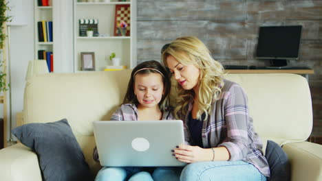 ein kleines mädchen und ihre mutter sitzen auf der couch im wohnzimmer