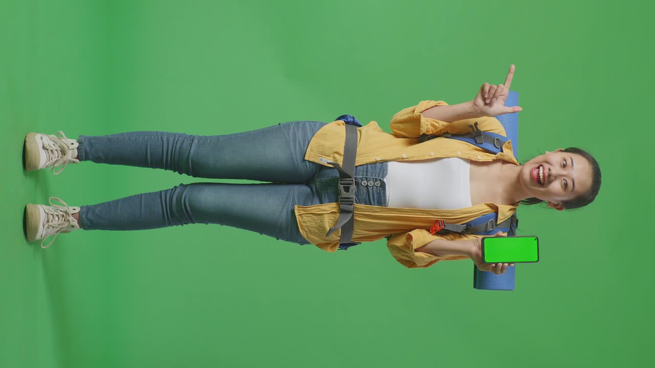 mujer con mochila y teléfono inteligente en pantalla verde