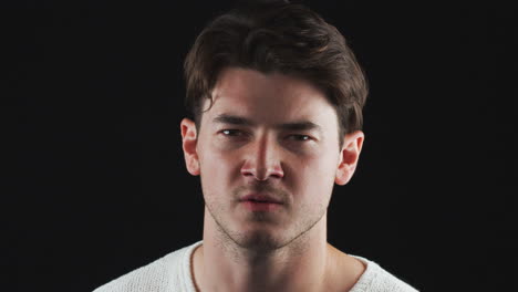 head and shoulders studio shot of angry man shouting at camera in slow motion