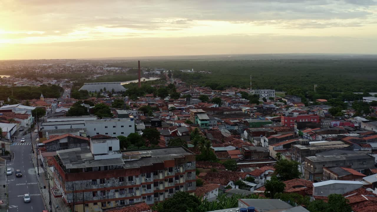 dolly en toma aérea de drones de un barrio pobre en el antiguo centro histórico de la capital costera tropical de joao pessoa, paraiba, brasil con casas, autos y fábricas durante la hora dorada