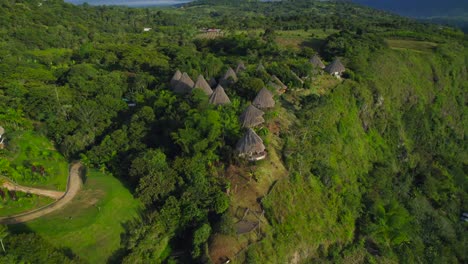 aerial dolly out revealing set of thatched roof huts hotel in the south american jungle