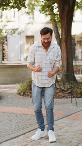 excited happy man traveler shouting celebrating success winning clenching fists walking on street