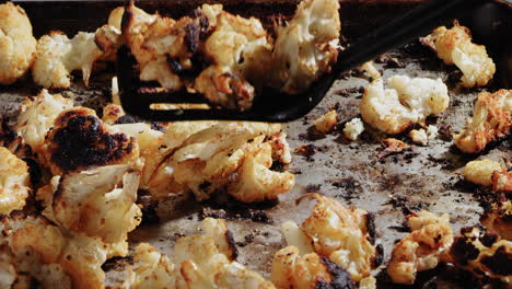 scooping up cauliflower with a spatula