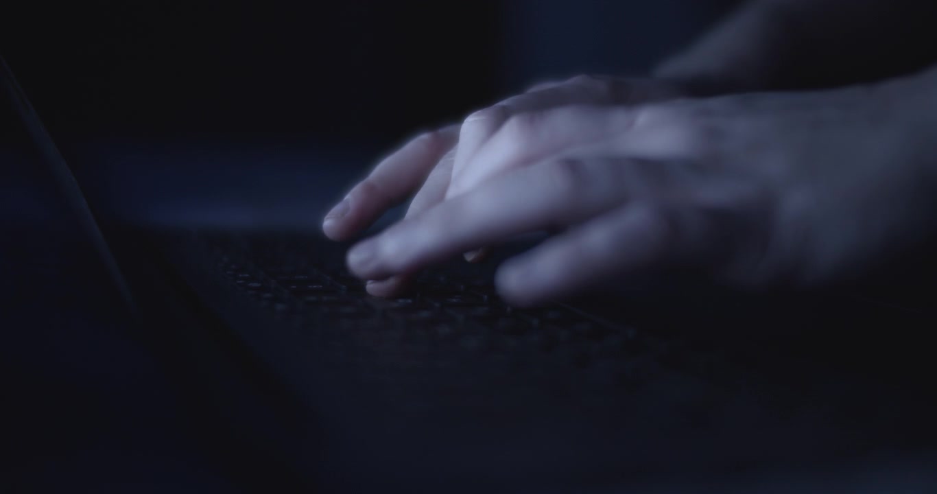 Primo piano di mani che digitano di notte