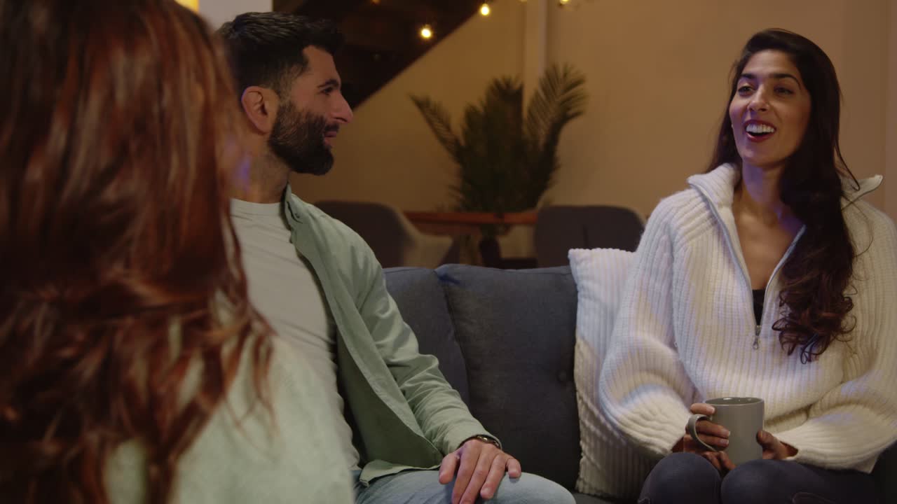 grupo de amigos relajados sentados en el sofá en casa o en un bar o cafetería hablando y bebiendo café juntos 10