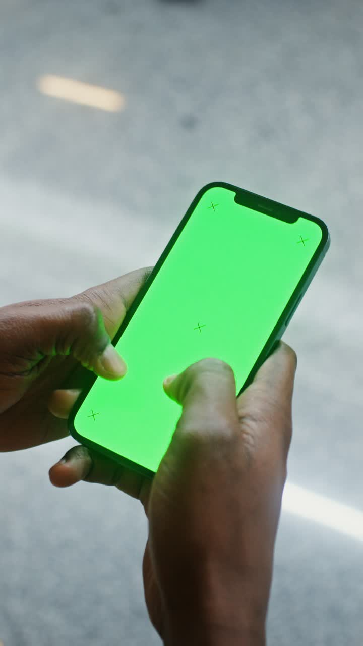 Smartphone with green screen being held