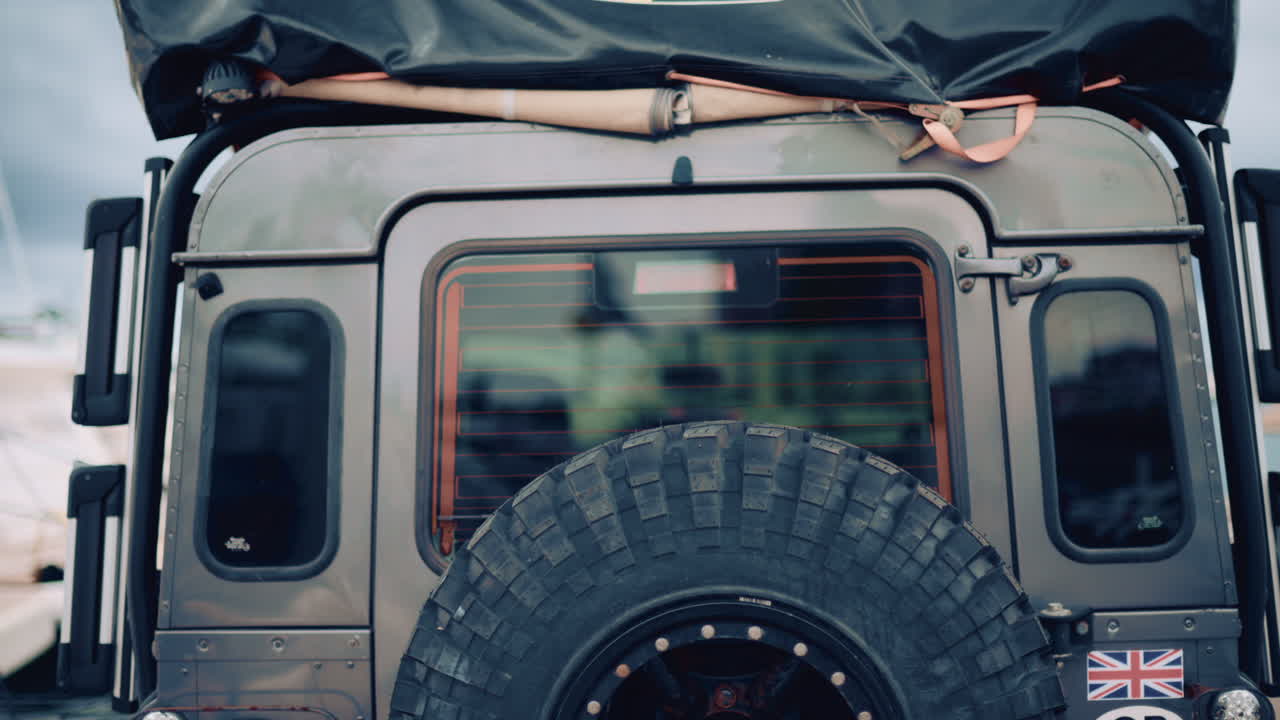 Back view of an off road vehicle equipped with spare tire and roof tent