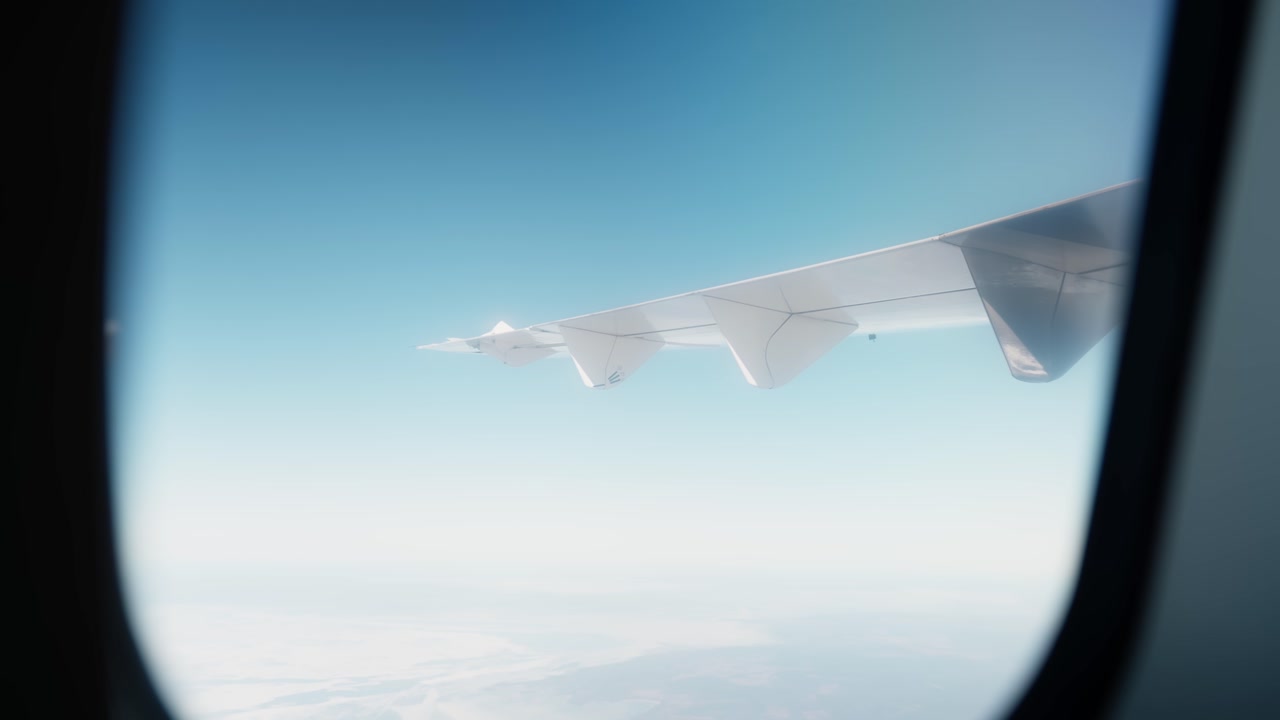 Passenger-window view of an airplane wing above a bright cloud layer, capturing clear-sky flight, cruising altitude, and the quiet perspective of modern air travel.