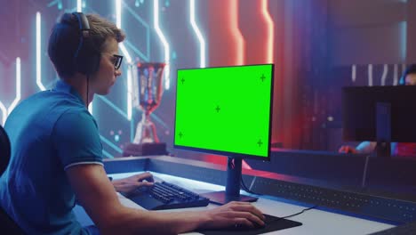 en el campeonato de videojuegos, el jugador de esports profesional juega en la pantalla clave de croma verde de la computadora personal. transmisión en vivo en línea del torneo de ciberjuegos. sala elegante. arco lateral disparo medio