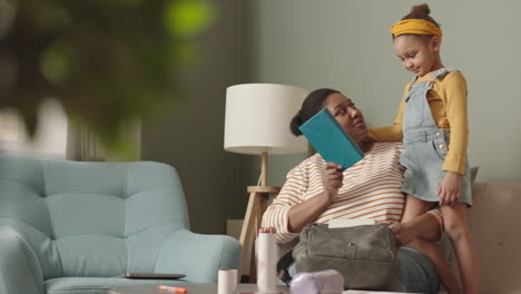 mother helping her daughter packing school bag