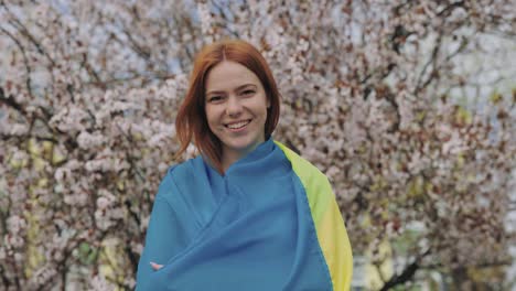 woman with ukrainian flag in spring