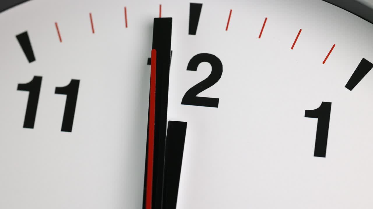 Large white wall clock Set the time for 12.00 o'clock. The red minute hand keeps running. Time lapse movie.