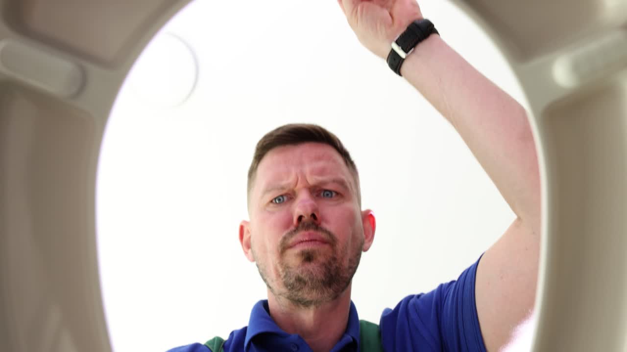 Man looking down into toilet