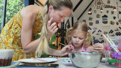 mother and daughter painting together
