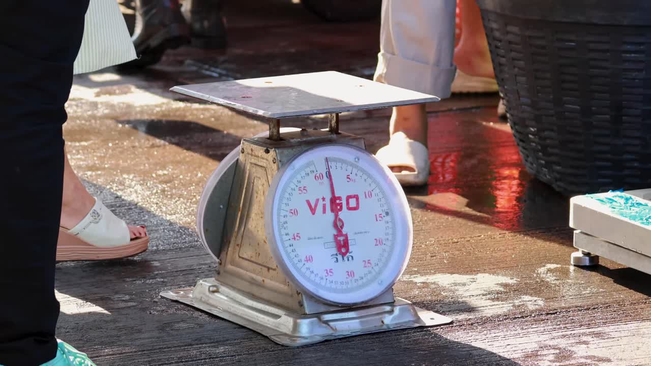 바쁜 시장 에서 무게 를 측정 하는 해산물