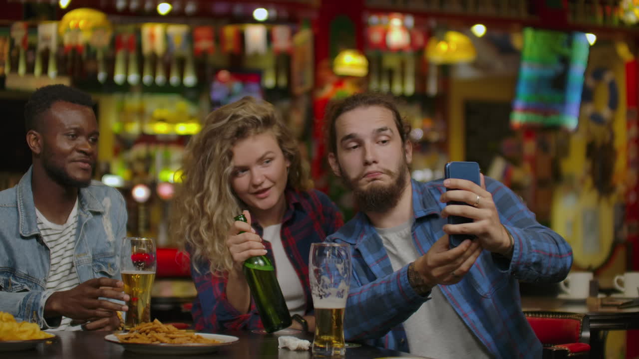 Amici maschi felici che si scattano un selfie e bevono birra al bar o al pub. Concetto di svago, amicizia, tecnologia e festa tra persone - amici maschi felici che si scattano un selfie