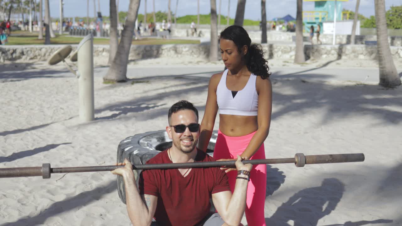 Mulher treinando homem em academia na praia