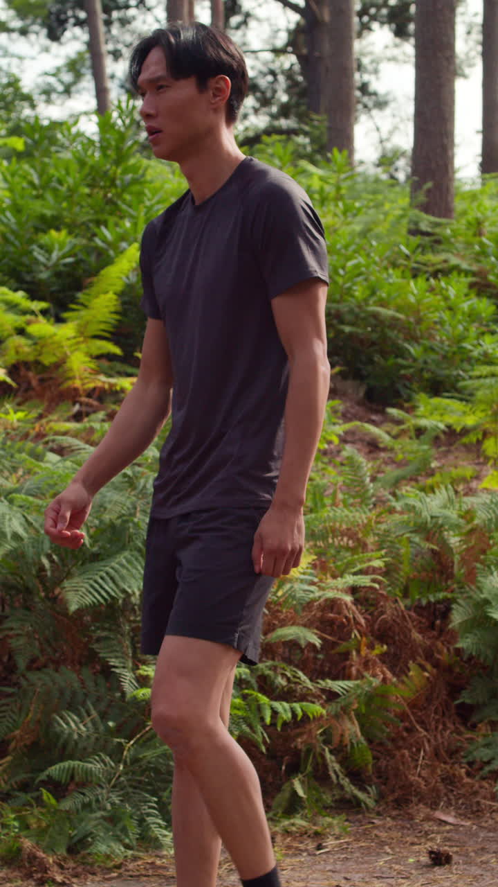 Vertical Video Of Man Warming Up And Stretching Before Work Out Exercising Running Through Forest Shot In Real Time 1