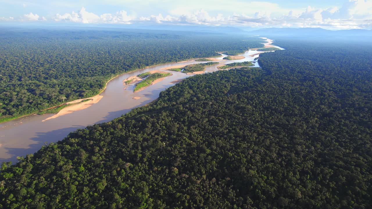 Aerial view reveals Peru’s mighty Amazon winding through endless stretches of lush green rainforest. Tambopata reserve