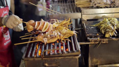 Grilled-Squid-on-a-charcoal-stove-at-Yaowarat-Road-Chinatown,-a-popular-travel-destination-in-Bangkok,-Thailand