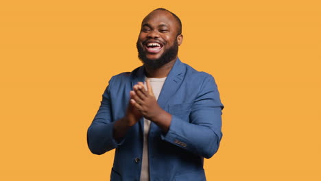 man happily clapping hands, applauding, studio background