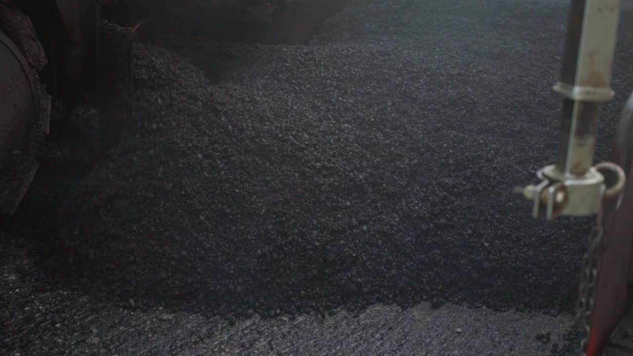 도로 건설을 위해 지상에 배포될 신선한 아스팔트, 낮은 각도에서 전면 보기