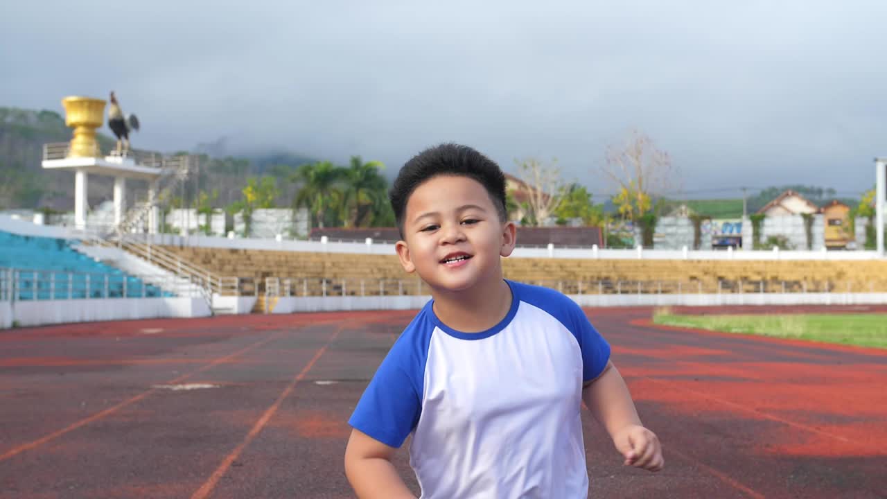 Happy Little Boy Running At Stadium