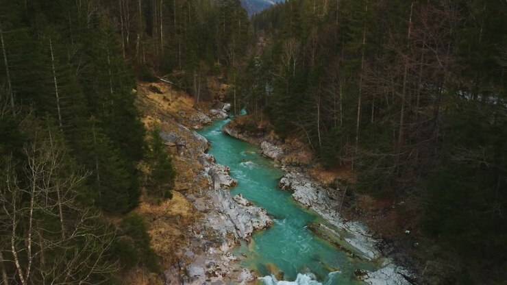 Fiume di montagna delle Alpi, cinemagraph aereo, video loop senza soluzione di continuità di una cascata idilliaca e panoramica per canyoning con acqua blu naturale e fresca nelle Alpi bavaresi e austriache, che scorre lungo gli alberi della foresta del canyon. 4K UHD. Rissach Tirolo Austria Engtal Ahornboden