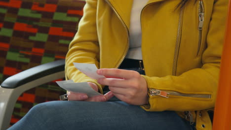 Close-Up-Of-Smiling-Woman-Sitting-In-Carriage-On-Underground-Train-Looking-At-Photos