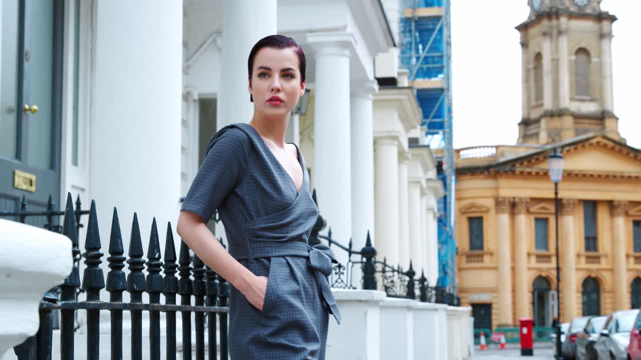 도시 거리에서 야외에 서 있는 패션 의식을 가진 젊은 여성