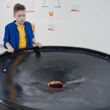 boy in the museum science. a planet swallowed by black hole simulation, endless gravity
