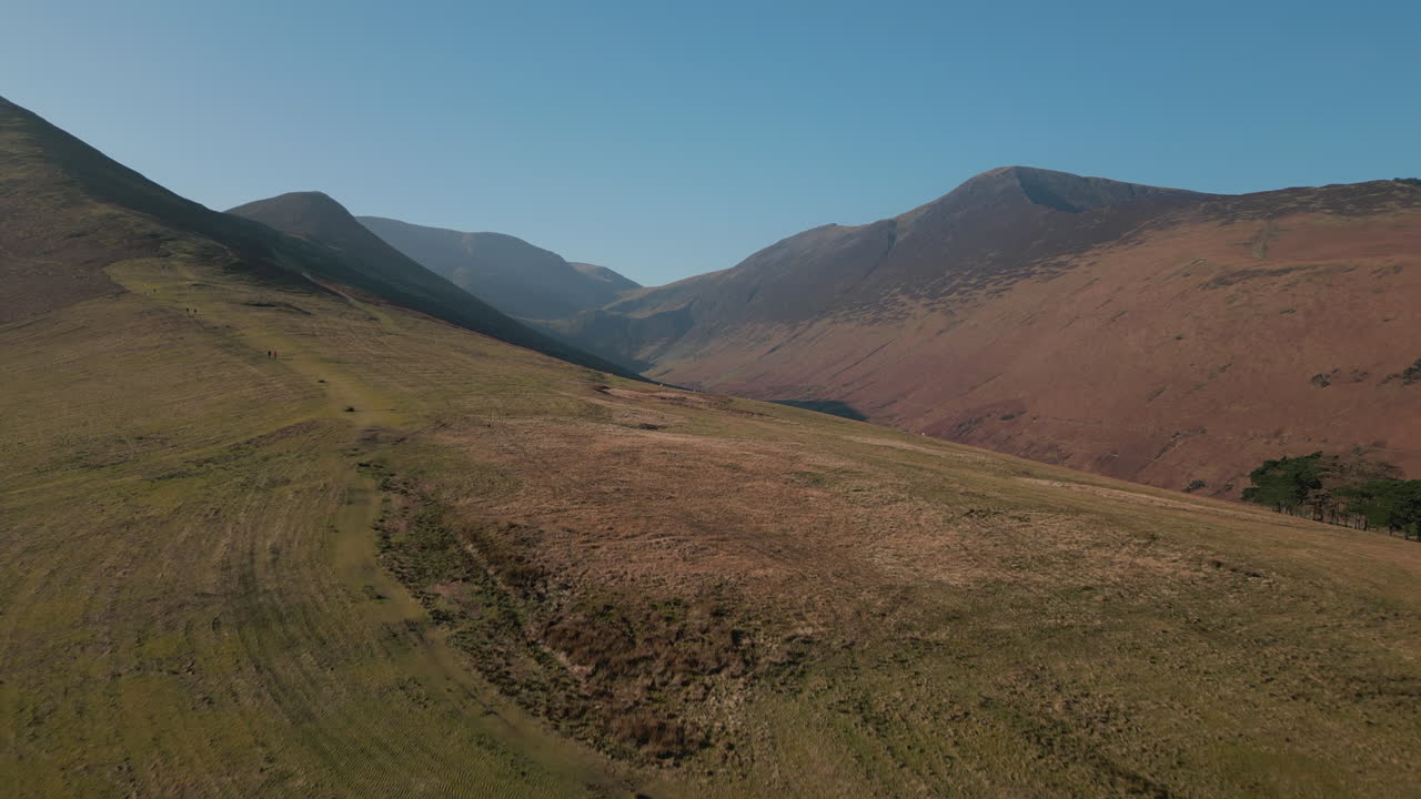Sorvolando i Fells di Lakeland verso montagne nebbiose che rivelano una valle in ombra nel Distretto dei Laghi inglese