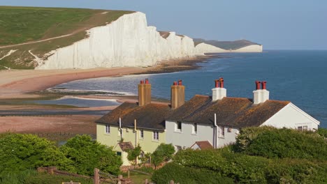 drone reveal of the coastguard cottages near seven sisters as the iconic white cliffs emerge dramatically in the background