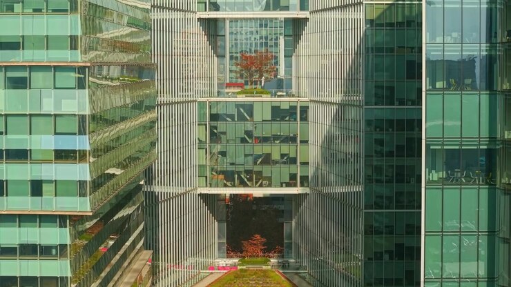Veduta aerea con dolly in avanti che inquadra un edificio moderno con aperture nella sua struttura a Nueva Las Condes in una giornata di sole, Santiago, Cile.