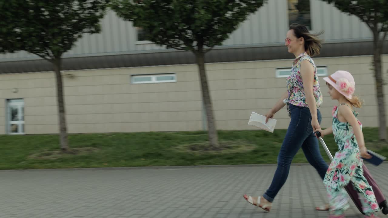 공항에서 걸어오는 어머니와 딸, 가방을 들고 다니는 여성, 휴가 후의 아이와 어머니