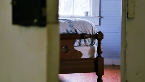 Smooth-left-to-right-dolly-shot-that-reveals-a-vintage-wooden-bed-being-bounced-and-shaking-suggestively-from-activity-on-the-bed